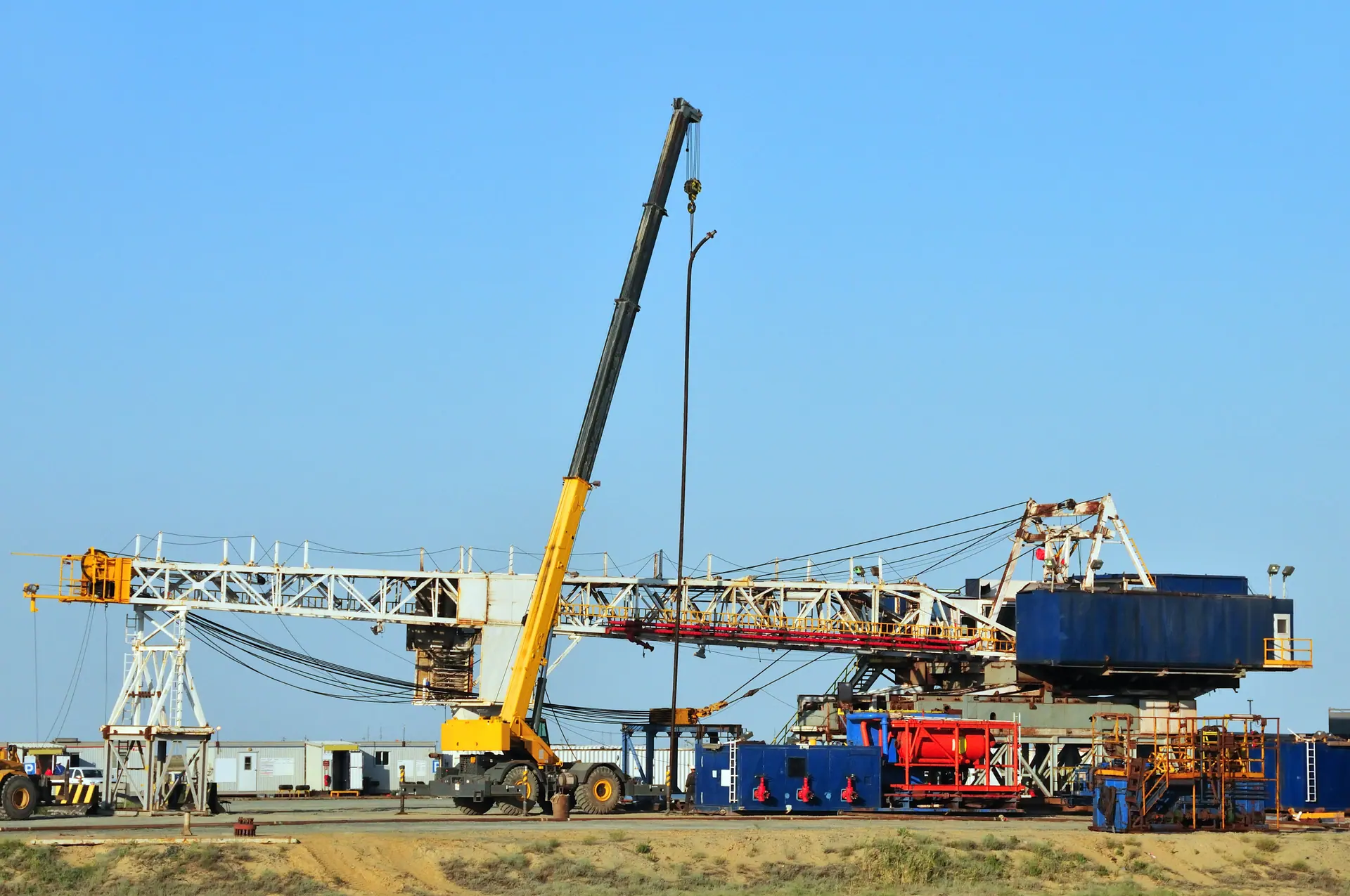 Mobile crane lifting a derrick section